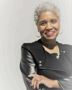 A woman with gray hair is smiling for the camera.